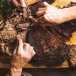 smoked-brisket-overhead-hands